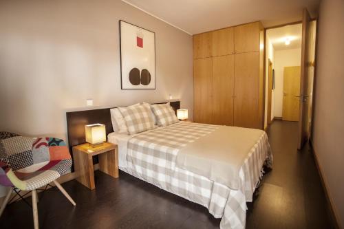 波尔图Casa do Sol的一间卧室配有一张床、一把椅子和一个橱柜
