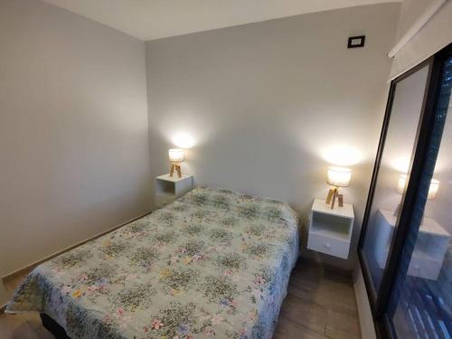 Las HerasDepartamento 3 personas的一间卧室配有一张床和两个带灯的床头柜