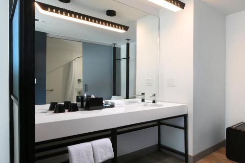 圆石城Aloft Austin Round Rock的浴室设有白色水槽和镜子