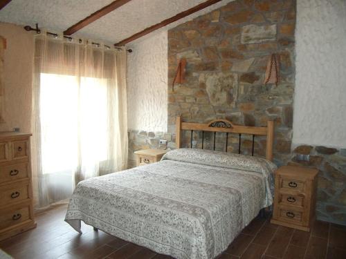 El GascoLas Casitas Del Bodegon的一间卧室设有一张床和石墙