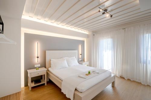 干尼亚Hanim Boutique Hotel的白色的卧室设有一张大床和一个窗户