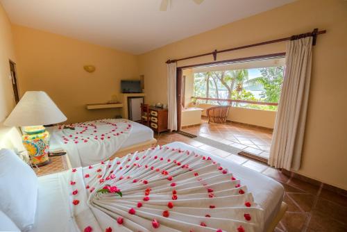 锡瓦塔塔内霍卡塔利娜海滩度假酒店的酒店客房,配有两张红色的床