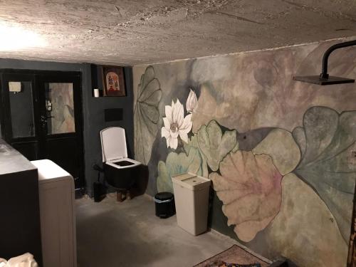 伊兹密尔Titan House Hostel的浴室墙上挂有鲜花壁画