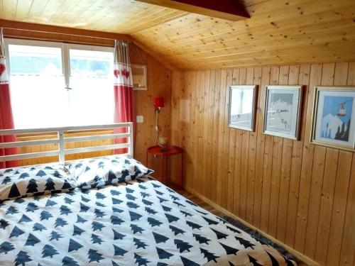 EngiGlärnisch Blick的木制客房内的一间卧室,配有一张床