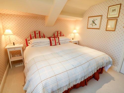 AustwickThe Garden Rooms Lawkland的一间卧室配有一张带铺着平底毯的床