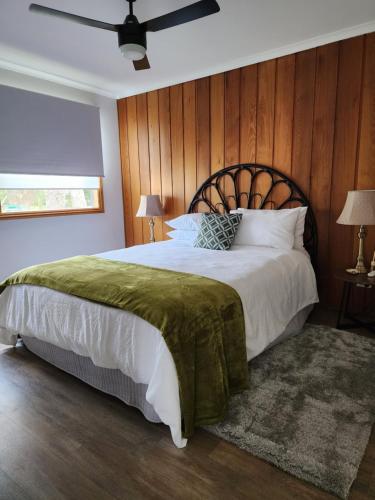 SeasprayVilletta al Mare的一间卧室设有一张带木墙的大床