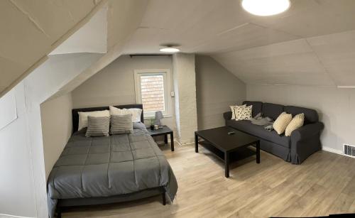 多伦多3-Bedroom House in Little Italy Downtown-Free Parking的一间卧室配有一张床和一个沙发