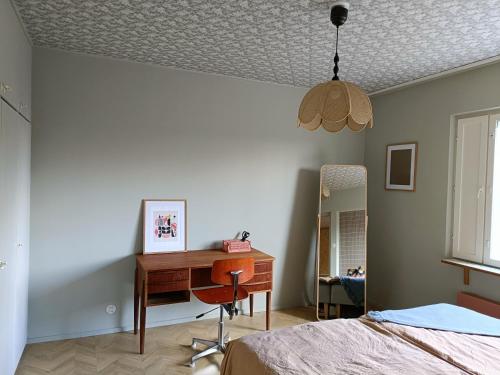 罗威萨Hieno kaksio keskustassa rauhallisella alueella的一间卧室配有书桌、一张床和镜子
