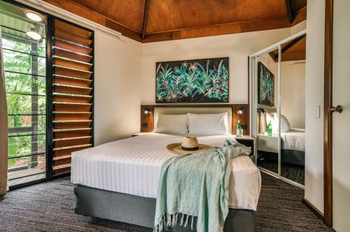 达尔文棕榈城度假酒店的一间卧室,配有一张床,上面有帽子