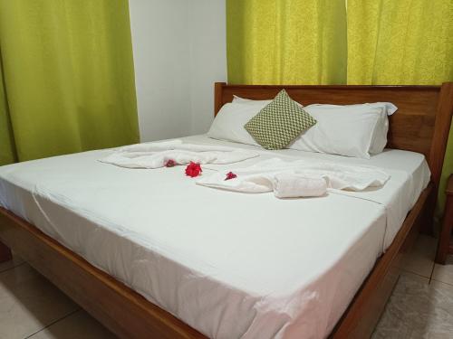 拉迪格岛Fern Lodge Self Catering的床上有毛巾和鲜花
