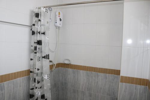 农布Cafe Nana Hotel的配有黑色和白色淋浴帘的淋浴