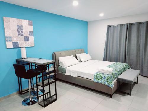 努尔德Apricity Suites Aruba的一间卧室配有一张床和一张桌子及椅子