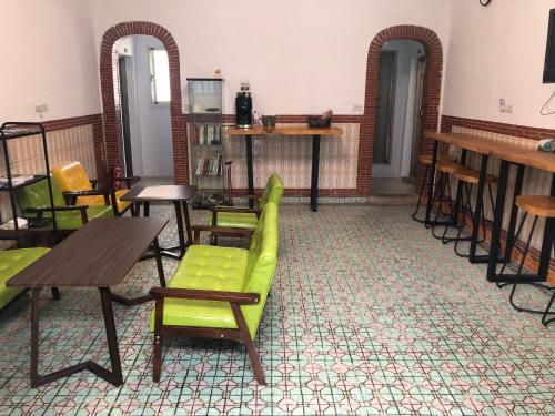 Hsi-kuo-shan不倒翁輕旅的一间设有绿色椅子和桌子的房间