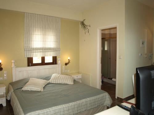 KyparissosPorto Mani Suites的一间卧室配有带两个枕头的床和窗户