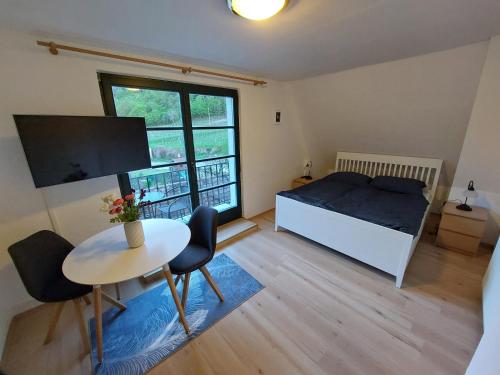 RossatzbachFerienhaus in der Wachau的一间卧室配有一张床、一张桌子和一个窗户。