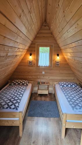 StahovicaLepa Lopa resort的小木屋内的两张床,设有窗户
