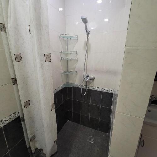 埃里温Family home的带淋浴的浴室,铺有瓷砖地板。