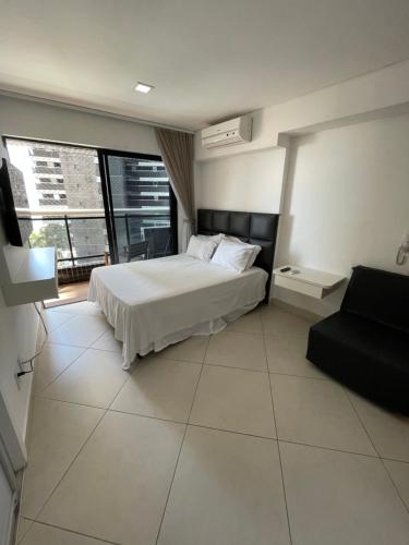 福塔莱萨Landscape Beira Mar Fortaleza的卧室配有白色的床和沙发