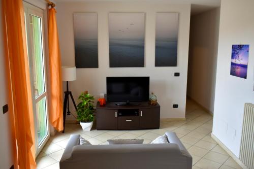 马里纳迪马萨Orange Apartment的带沙发和电视的客厅