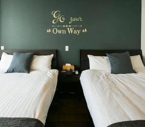 鹿儿岛ROI SPACE 鹿児島的两张睡床彼此相邻,位于一个房间里