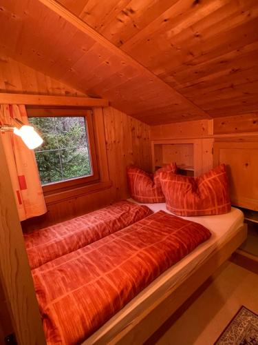 阿尔卑巴赫Alpapart Schneider的木制客房的一张床位,设有窗户