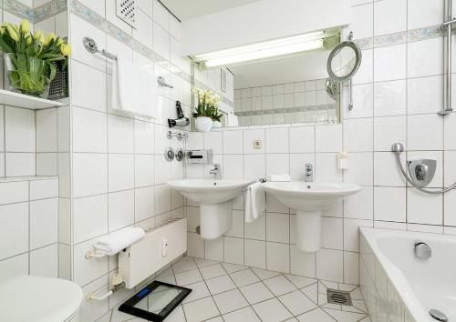 韦斯特兰Strandhotel Monbijou GmbH garni的白色的浴室设有两个盥洗盆和镜子