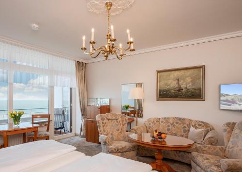 韦斯特兰Strandhotel Monbijou GmbH garni的一间带一张床和吊灯的客厅