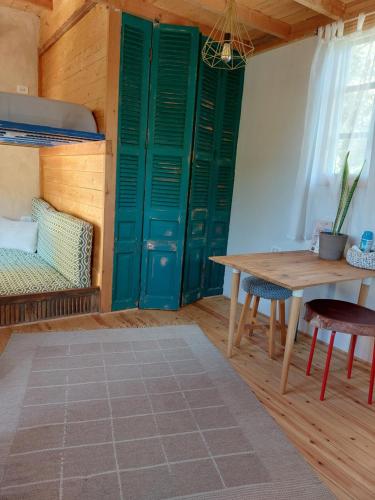 IbshawāyEl Sheesh by Barefoot in Tunis的一间设有绿门、桌子和床的房间
