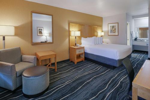 科斯塔梅萨梅萨海岸/纽波特海滩华美达旅馆及套房酒店的配有一张床和一把椅子的酒店客房