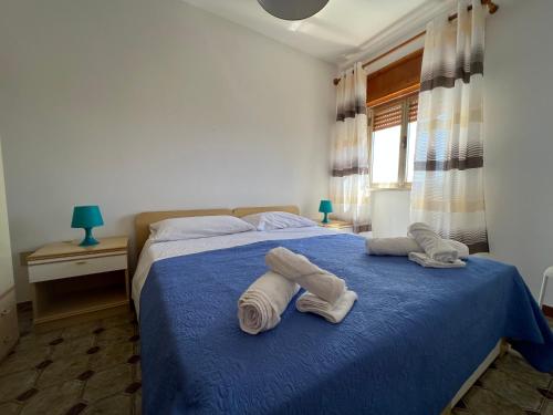 莱波拉诺亚特兰堤公寓酒店的一间卧室配有蓝色的床和毛巾