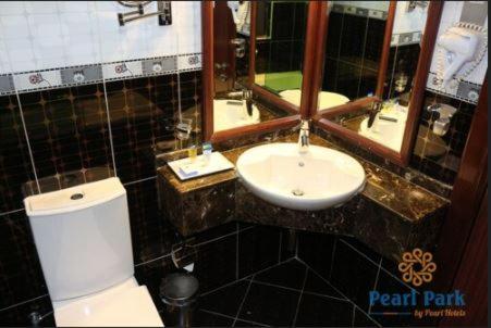 迪拜Pearl Executive Hotel Apartments的浴室配有白色卫生间和盥洗盆。