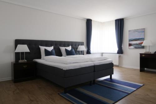 奥尔堡赫尔南凤凰酒店的一间卧室配有一张带蓝色枕头的大床