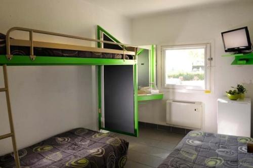 塞普特梅斯·莱瓦隆勒芒酒店的一间卧室设有两张双层床和一扇窗户。