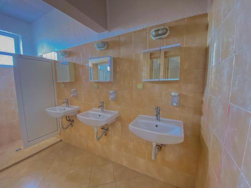 斯维什托夫Пансион - Димитър Хадживасилев的浴室设有3个水槽和2面镜子