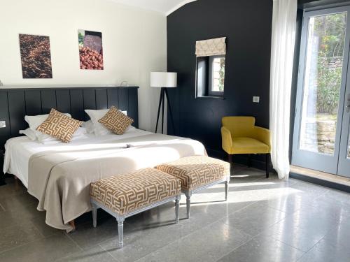戈尔德Domaine de l'Enclos的一间卧室配有一张大床和一张黄色椅子