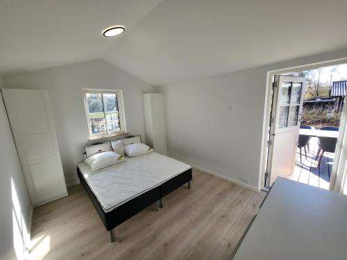 斯坎讷堡Sommerhus ved Mossø med søkig的一间卧室设有一张床和一个大窗户