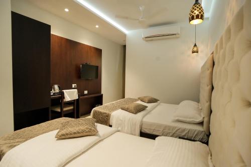 埃尔讷古勒姆Sulu Residency的酒店客房配有两张床和一张书桌