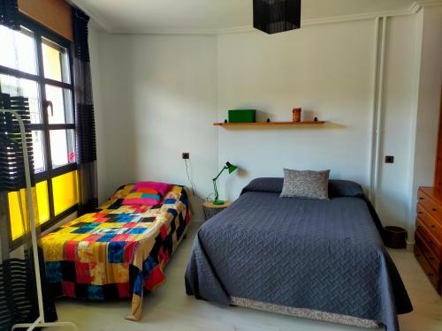 蓬费拉达Apartamento en el casco antiguo de Ponferrada的一间卧室设有两张床和窗户。