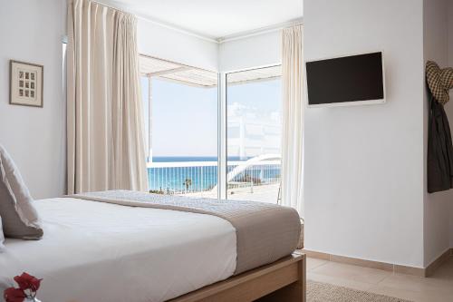 雅典Sea View Beach Penthouse - Athens Coast的一间卧室设有一张床和一个大窗户