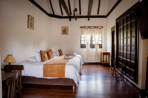 派帕Hotel Hacienda El Salitre的一间卧室设有两张床和窗户。