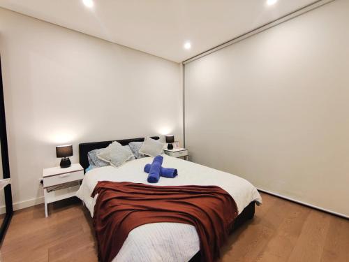悉尼3BR Apt near Stadiums, Family-Friendly, Cozy decor的一间卧室配有一张带蓝色丝带的床