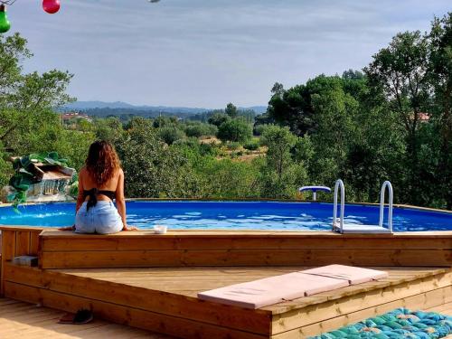 托马尔Quinta da Choupana的坐在游泳池旁甲板上的女人