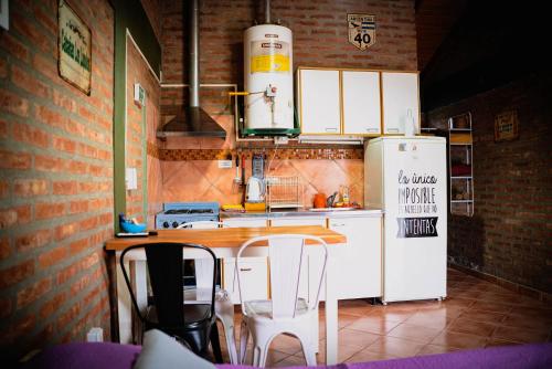 埃博森Cabañas Los Lúpulos的厨房配有白色冰箱、桌子和椅子
