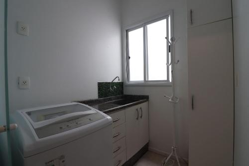 弗洛里亚诺波利斯Apartamento com banheira para um banho relaxante - HB67F的白色的浴室设有水槽和窗户。