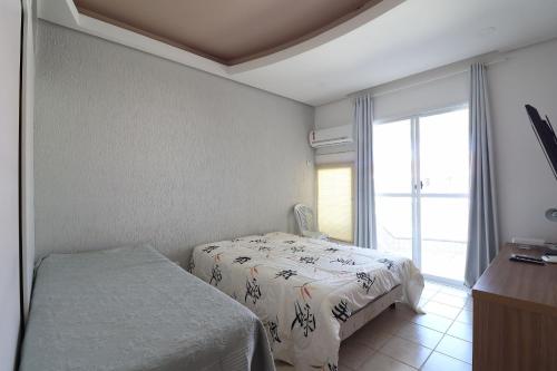 弗洛里亚诺波利斯Apartamento com banheira para um banho relaxante - HB67F的一间卧室设有一张床和一个大窗户