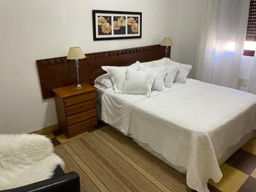 卡梅隆“Nelly’s House” Excelente Ubicación y Confort的卧室配有一张带白色床单和枕头的大床。