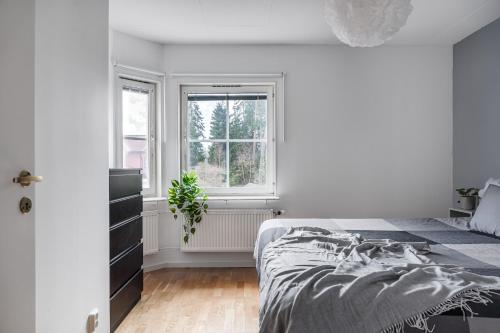 乌普萨拉Uppsala Large family home beside forest的白色的卧室设有床和窗户