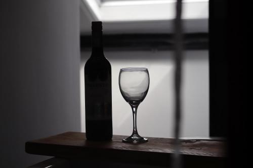 纳尔斯伯勒Berry's Loft - Central Location and Fast WIFI的一瓶葡萄酒和一杯酒在桌子上