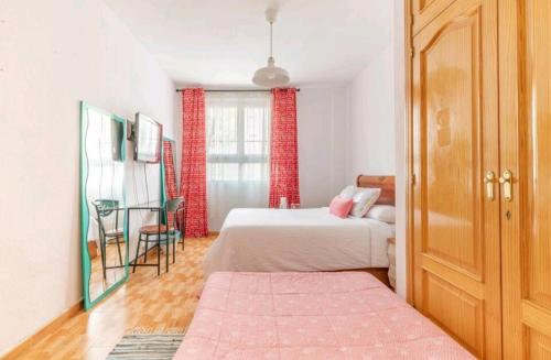 马德里Acogedora Habitación en Madrid的一间卧室配有两张床和一张桌子