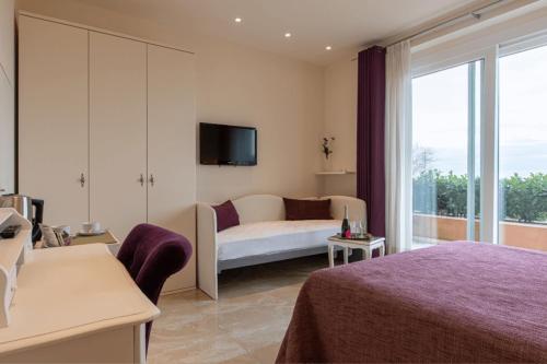MonteluponeVILLA GARULLI的一间酒店客房,配有一张床和一台电视